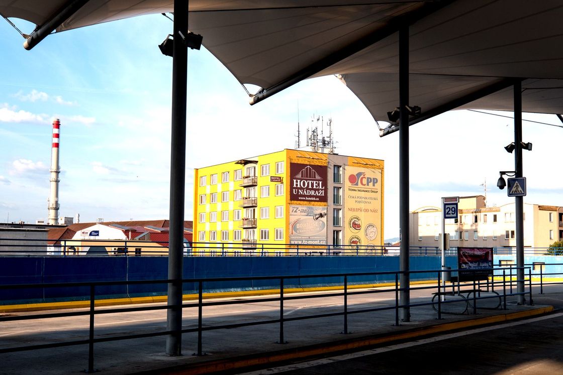 Hotel U Nádraží viděný zpod zastřešení nástupiště autobusového terminálu naproti